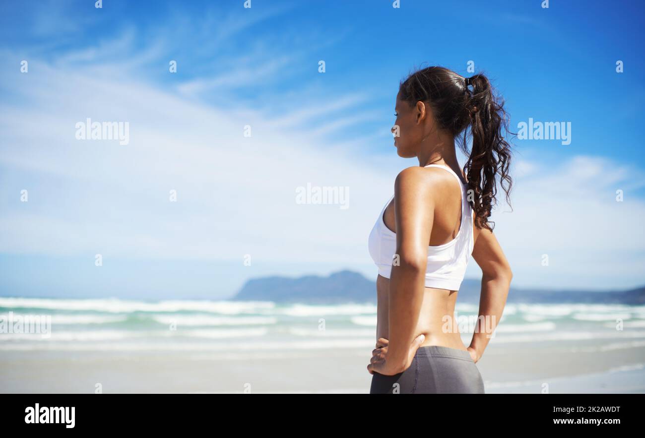 Forma e salute. Un giovane pareggiatore in piedi sulla spiaggia. Foto Stock