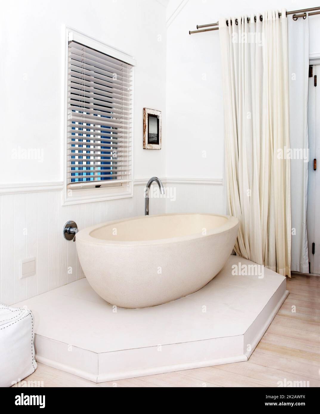 Entrate nel lusso moderno. Splendida vasca bianca nell'angolo di un bagno elegante. Foto Stock