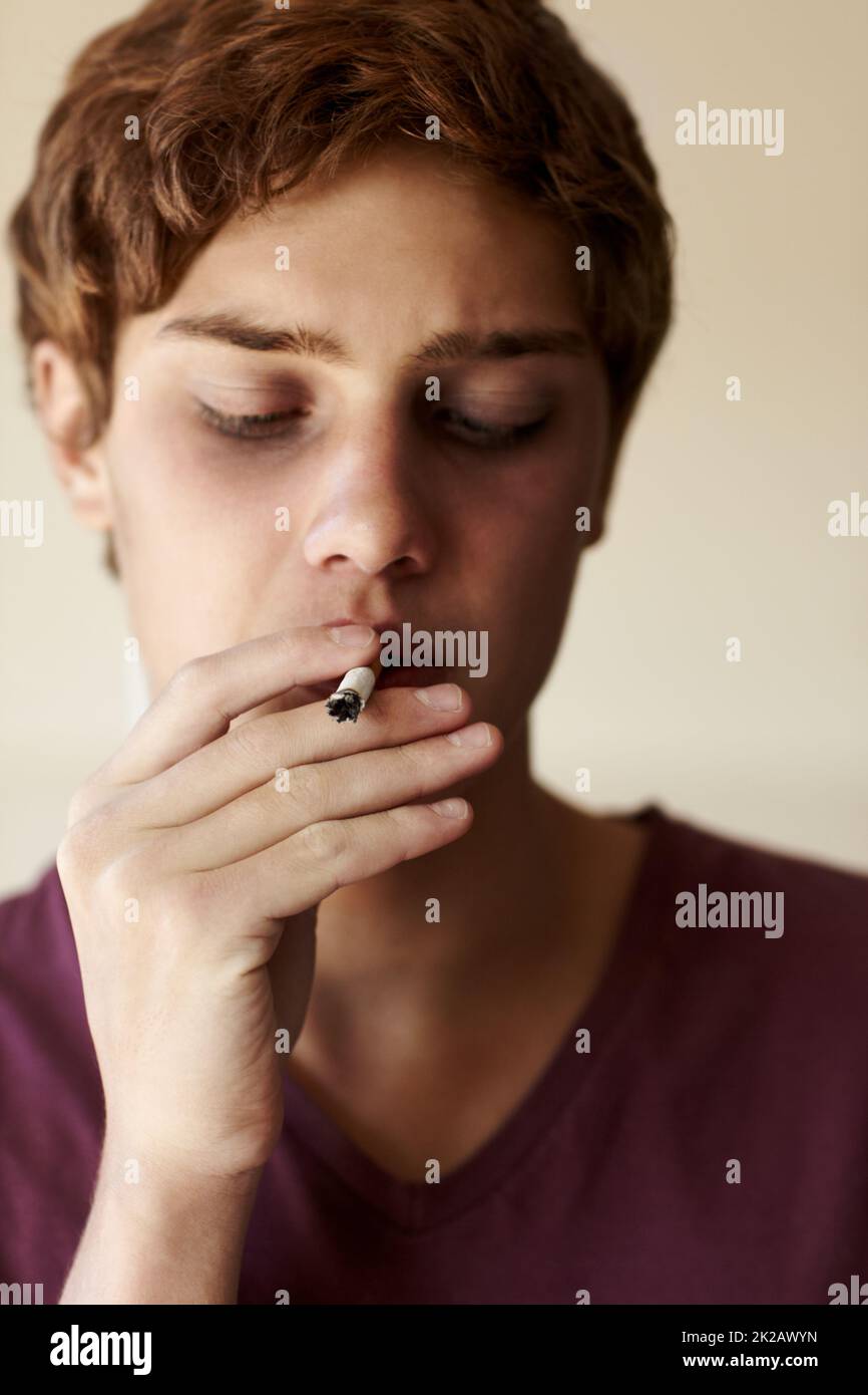 Solo provarlo Primo piano di una persona che fuma una sigaretta. Foto Stock