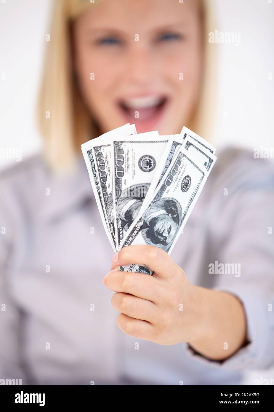 Denaro guadagnato duramente. Una giovane donna che ti mostra un'ira di denaro eccitata. Foto Stock