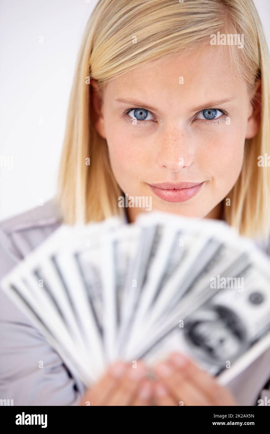 Dovete lavorare duro se volete questo. Una donna che tiene in mano una borra di denaro con uno sguardo impegnativo nei suoi occhi. Foto Stock