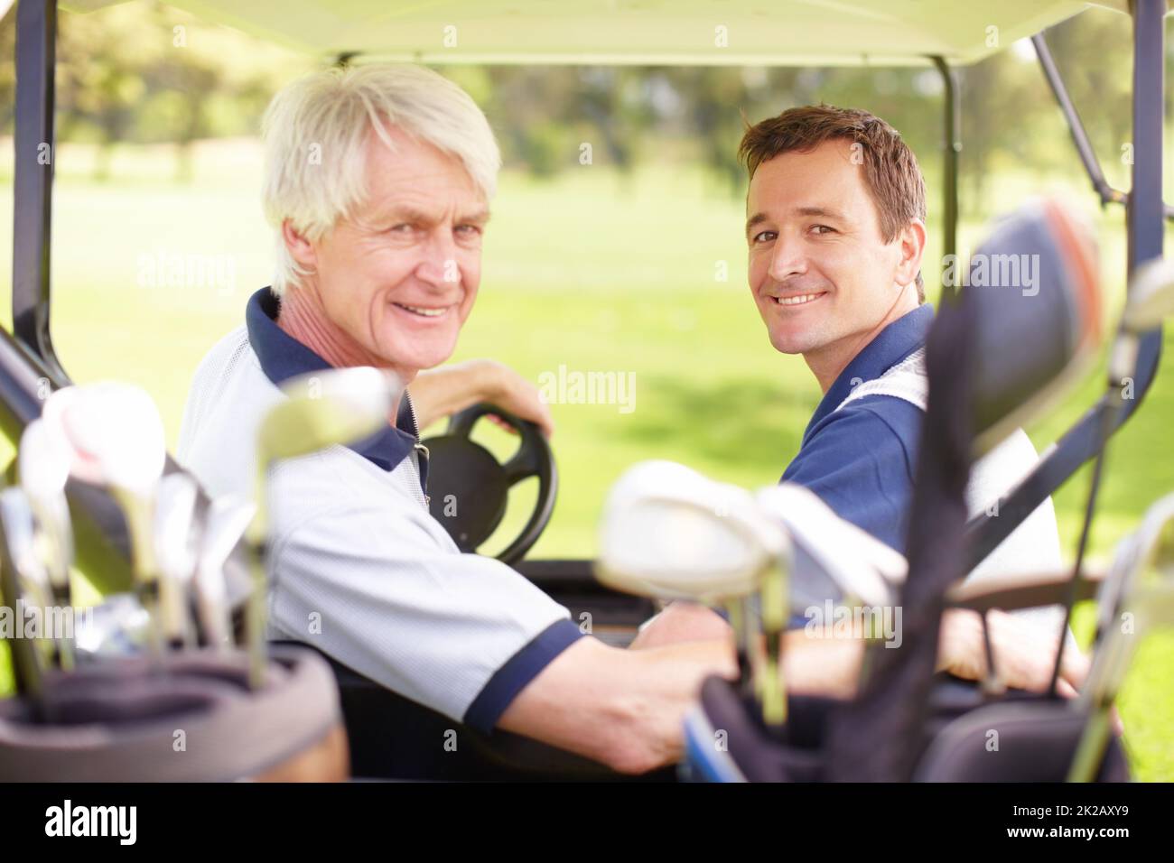 Amici del golf. Compagni di golf sul campo da golf in un golf cart. Foto Stock