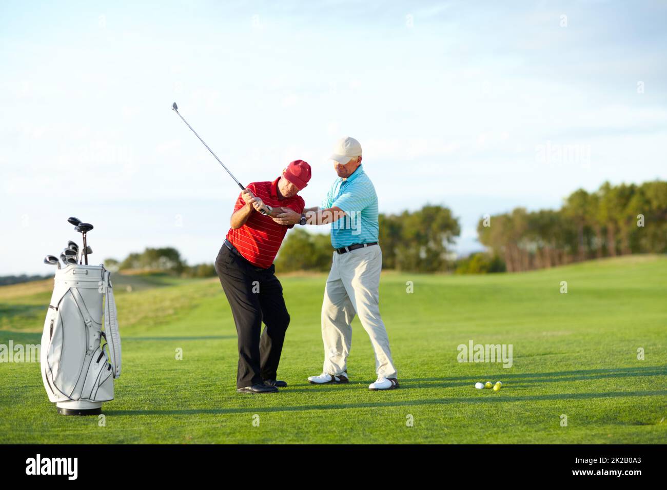 La tecnica corretta. Un golfer maschio che ottiene l'aiuto dal suo caddy sul campo da golf. Foto Stock