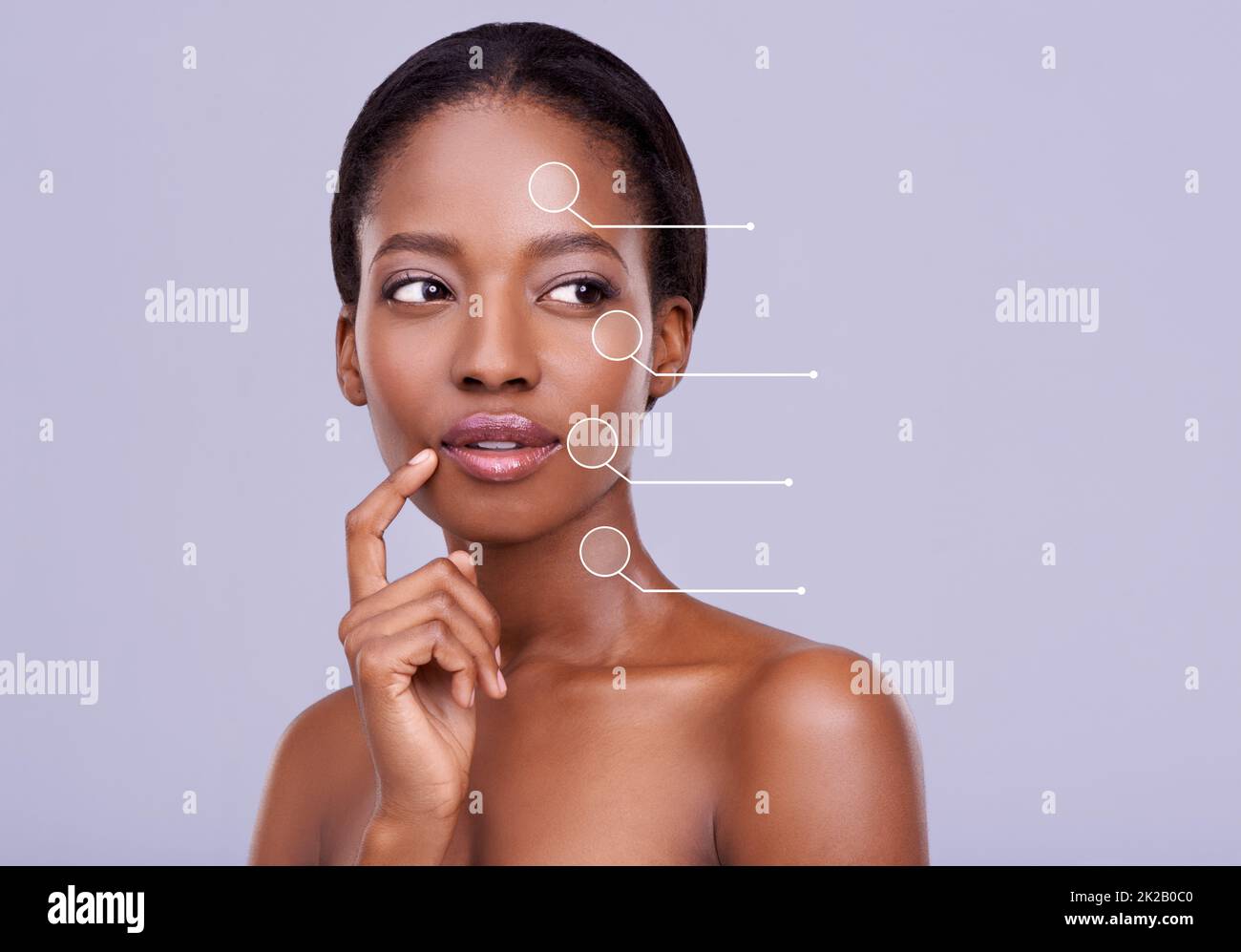 Prendendosi cura della sua pelle. Scatto corto di una bella donna africana su sfondo viola. Foto Stock