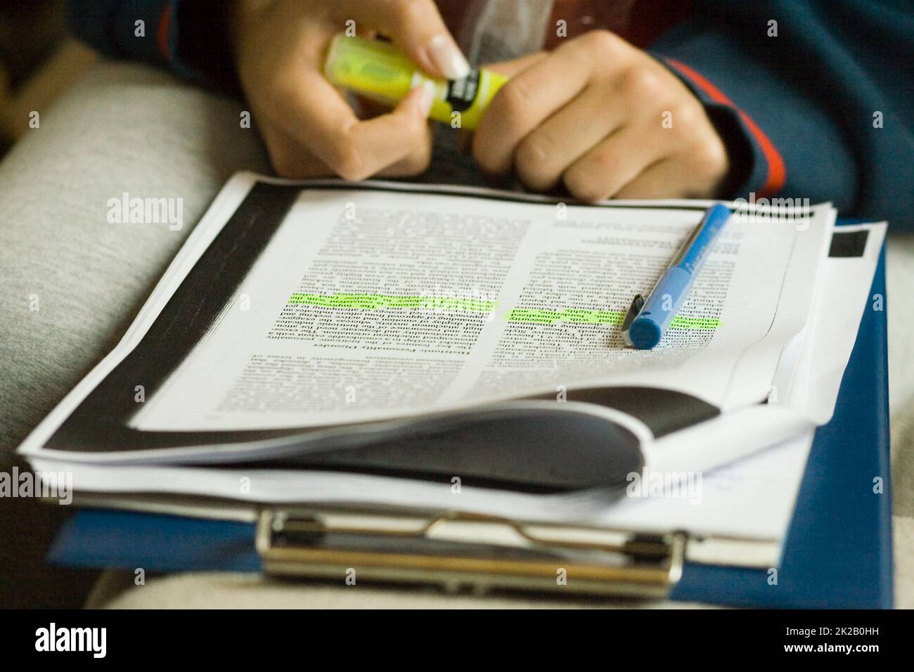 Evidenziazione. Foto di uno studente che evidenzia il testo durante lo studio. Foto Stock