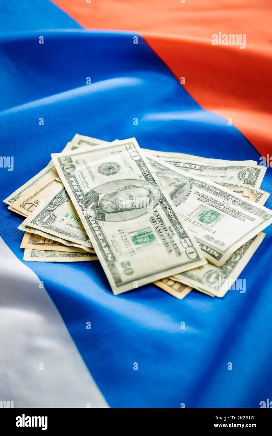 Banconote IN dollari USA poste sulla bandiera russa. Foto Stock