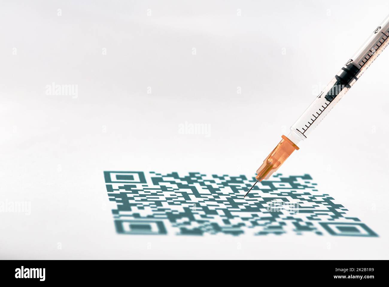 Un primo piano con codice QR e una siringa medica Foto Stock