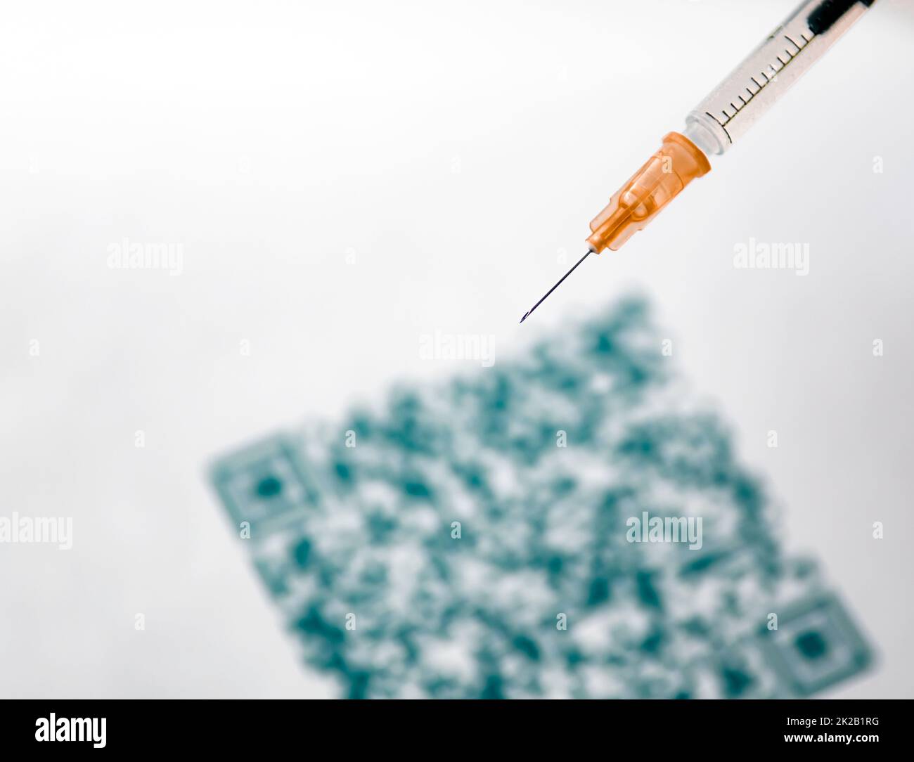 Un primo piano con codice QR e una siringa medica Foto Stock