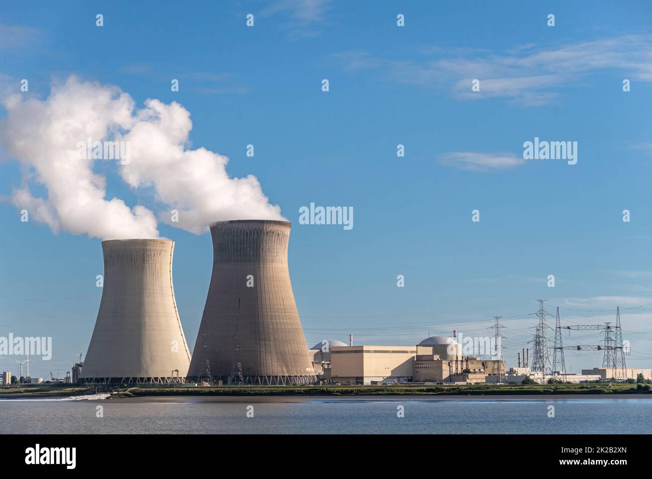 Antwerpen, Fiandre, Belgio - 10 luglio 2022: Paesaggio, torri di raffreddamento che soffiano vapore in aria blu in serata, e edifici della centrale nucleare di Doel, Foto Stock