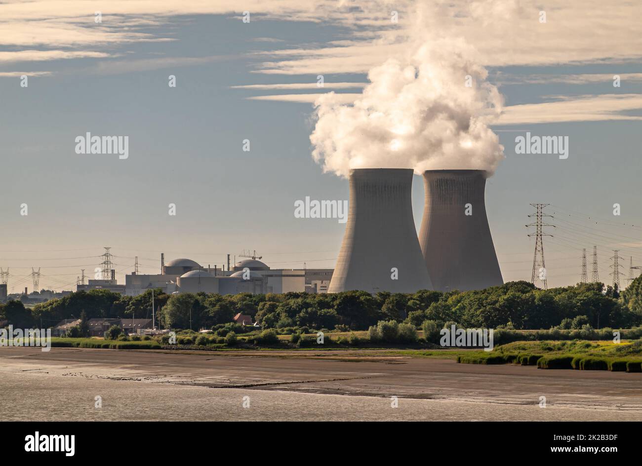 Antwerpen, Fiandre, Belgio - 10 luglio 2022: Torri di raffreddamento e centrale nucleare di Doel dietro il litorale del fiume Scheldt e la riserva naturale verde. LIG Foto Stock