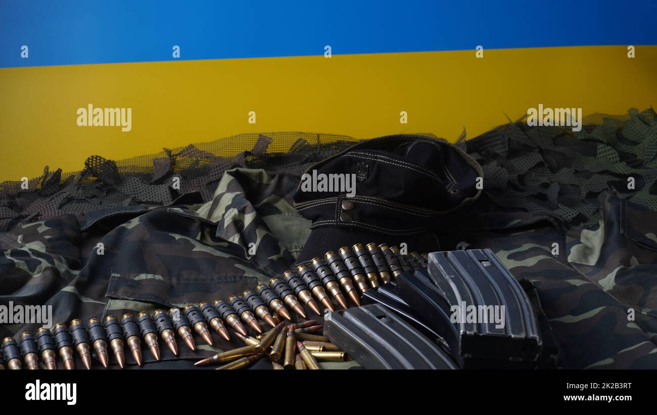 Bandiera blu-gialla di Ucraina simbolo nazionale, munizioni 5,56mm, cintura proiettili mitragliatrici, munizioni fucile in riviste, uniforme Ucraina e Army Black Cap Foto Stock