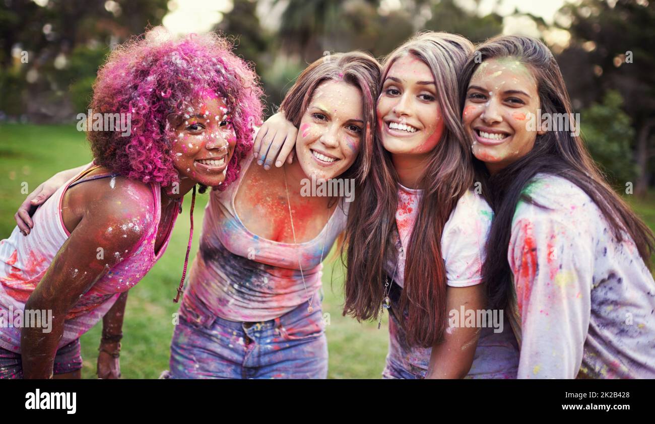 Pieno di colore. Amici felici che si divertono con la vernice in polvere. Foto Stock