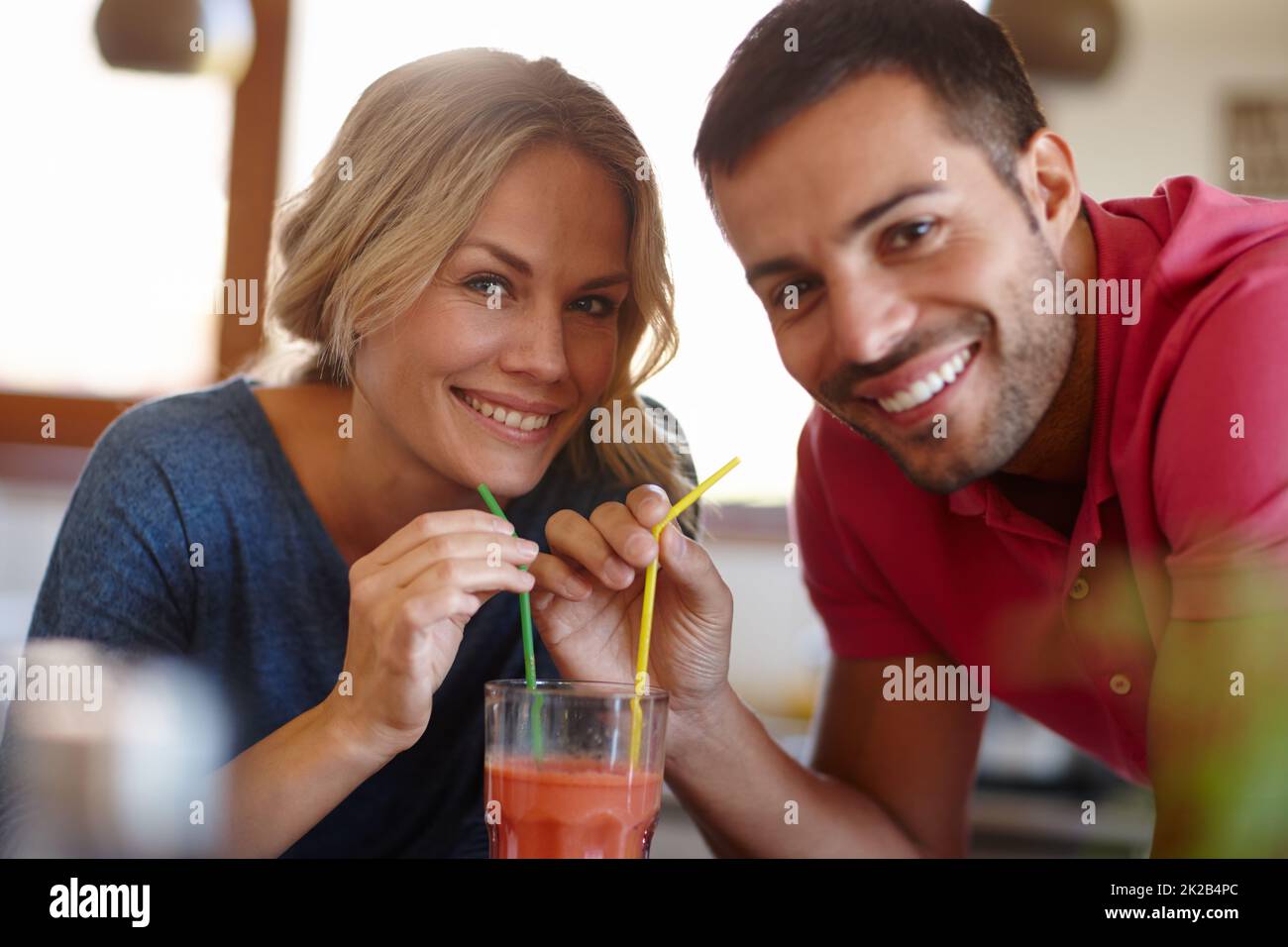 Il romanticismo della vecchia scuola. Scatto di una giovane coppia felice che condivide un milkshake. Foto Stock