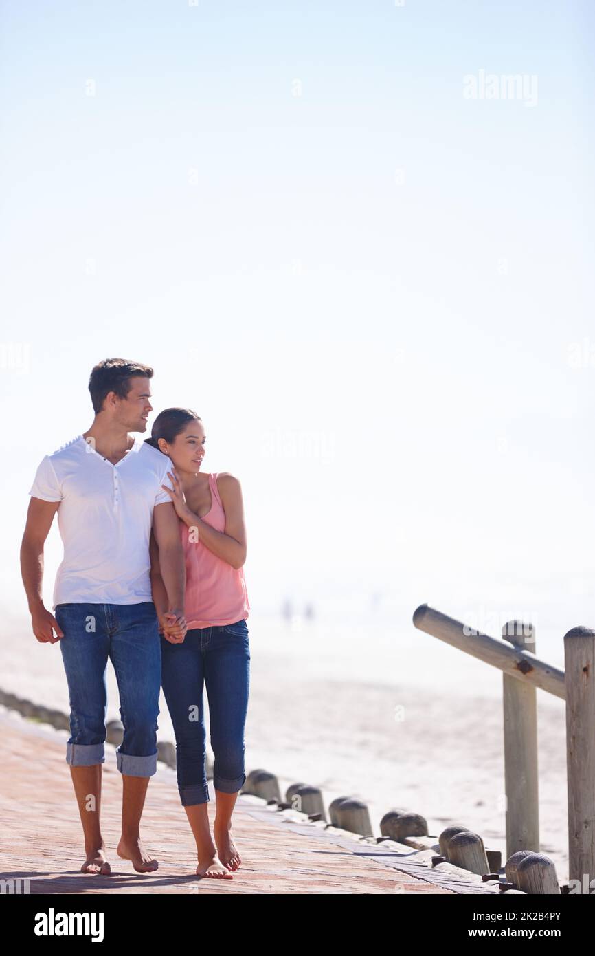 Amore e una bella vista. Scatto a tutta lunghezza di una giovane coppia attraente che cammina accanto al mare. Foto Stock