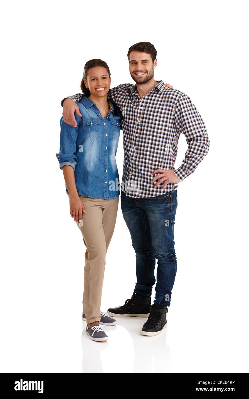 Felice e innamorato. Studio ritratto di una giovane coppia affettuosa in piedi con le braccia l'una intorno all'altra isolato su bianco. Foto Stock
