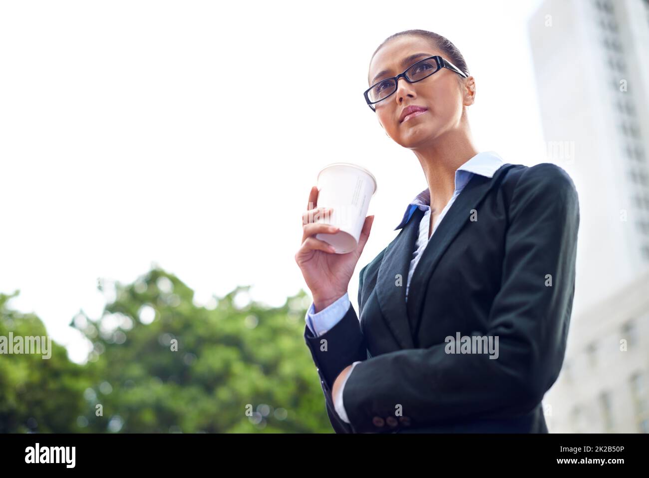 Pausa caffè a mezzogiorno. Shot di una donna d'affari che tiene una tazza di caffè durante la sua pausa. Foto Stock