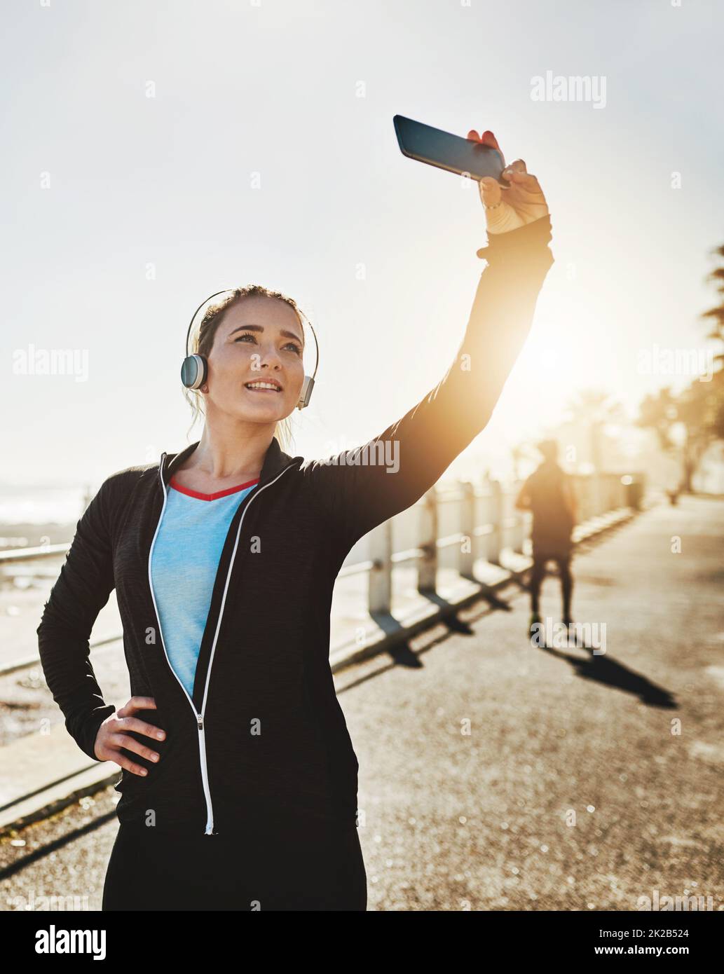 Ispira anche gli altri a vivere in buona salute. Scatto corto di una giovane donna sportiva che prende un selfie mentre fuori sul lungomare. Foto Stock