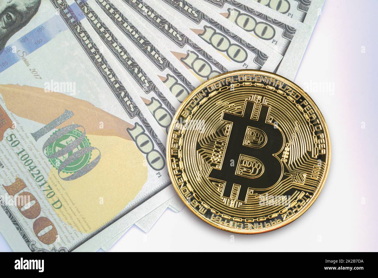 Monete Bitcoin e banconote statunitensi da cento dollari Foto Stock