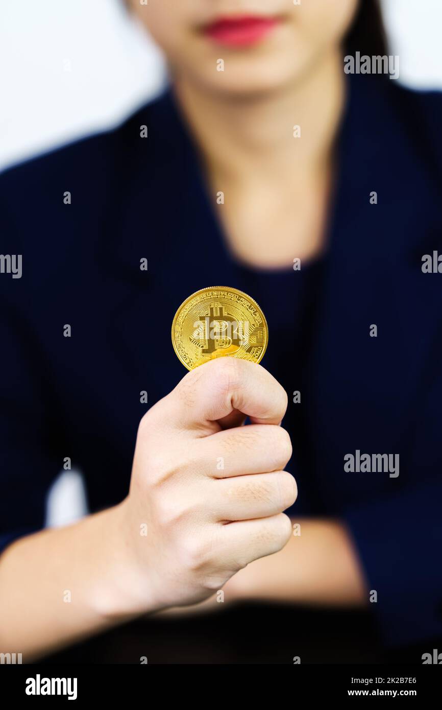 Primo piano donna d'affari in possesso di alcuni pezzi di Bitcoin gettone d'oro Foto Stock