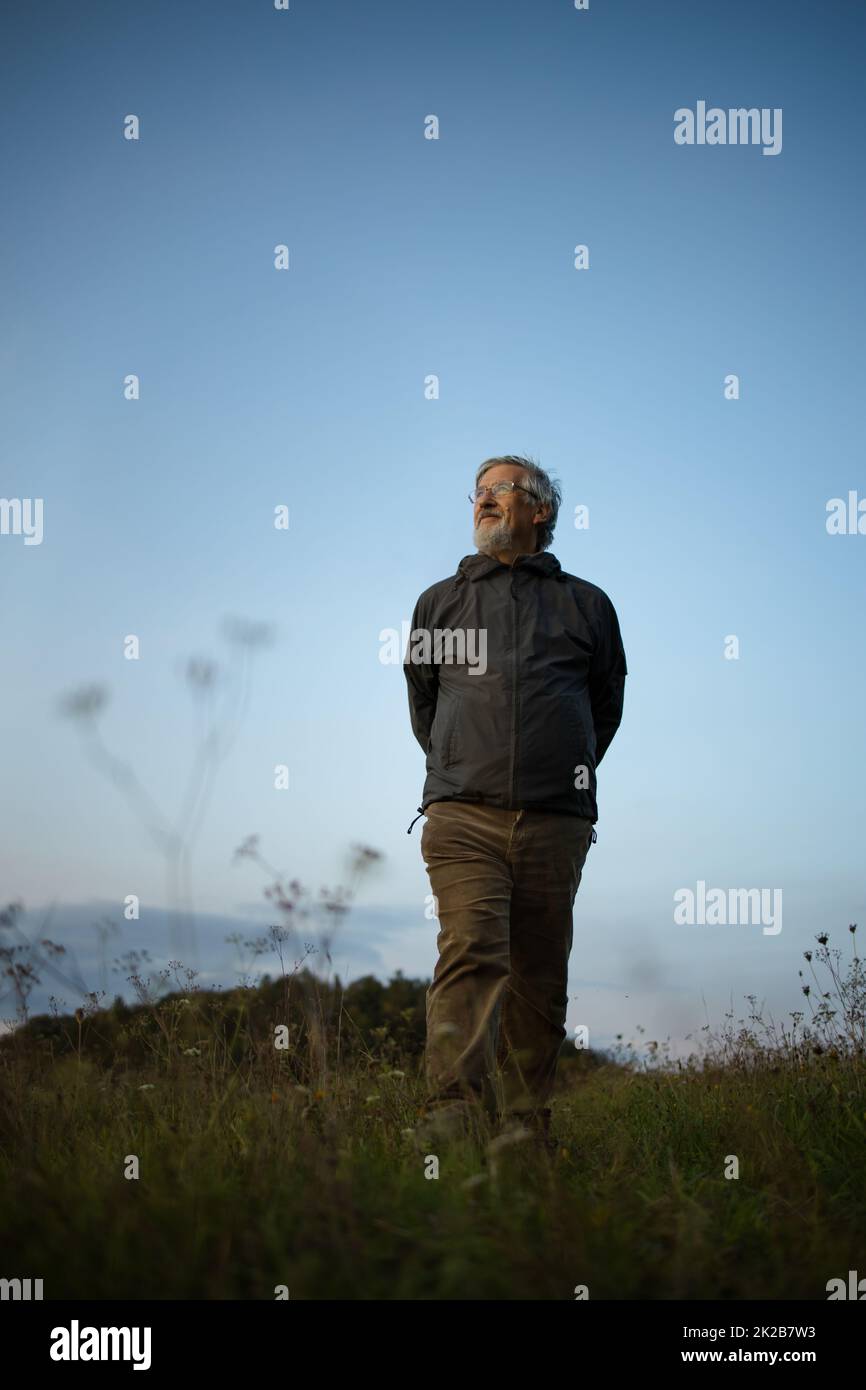 Uomo anziano che ama godersi la natura, fare escursioni, camminare nella natura Foto Stock