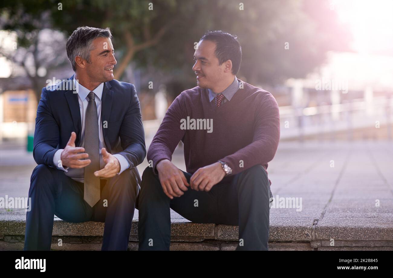 Così vedi Shot di due uomini d'affari che hanno una discussione mentre seduti fuori. Foto Stock