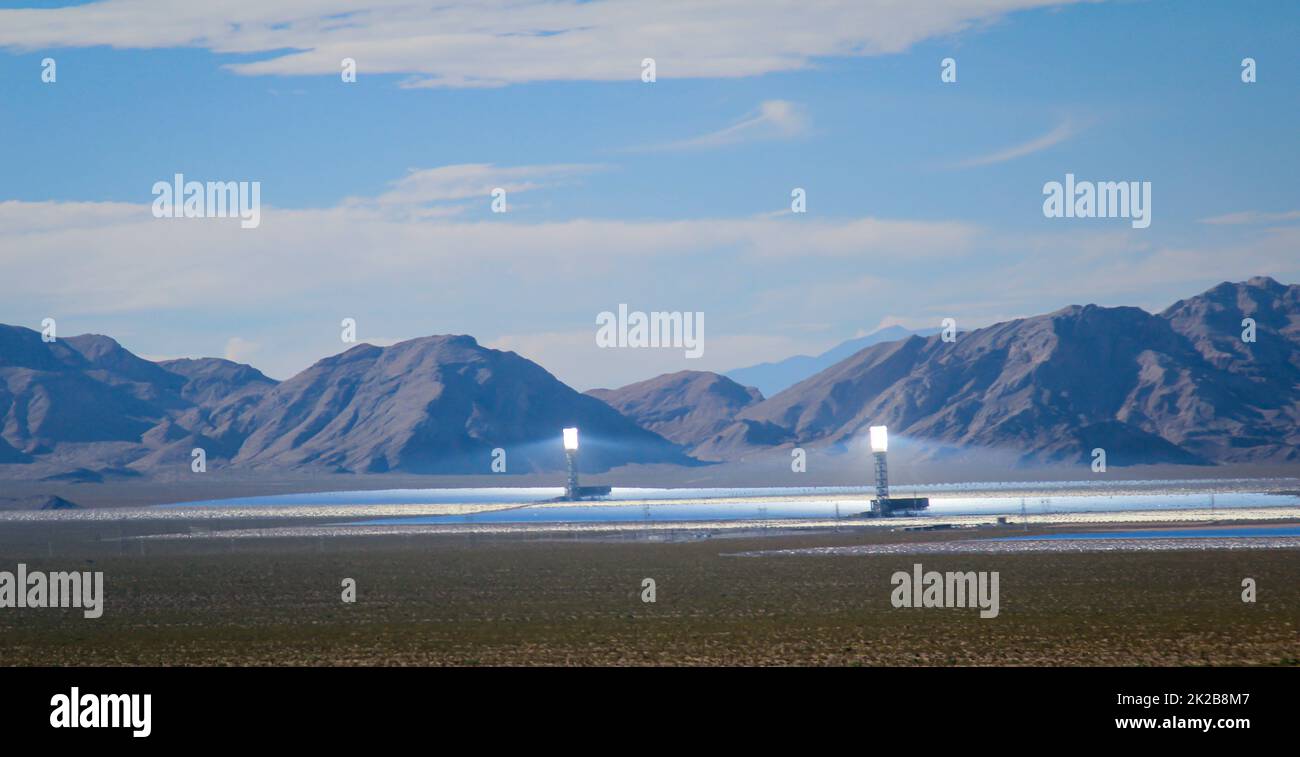 Vista su una centrale solare situata su una pianura di fronte ad un massiccio montano. Foto Stock