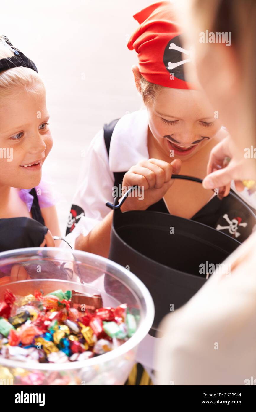La gioia di ricevere. Un fratello e una sorella ricevono dolci da un vicino su Halloween. Foto Stock