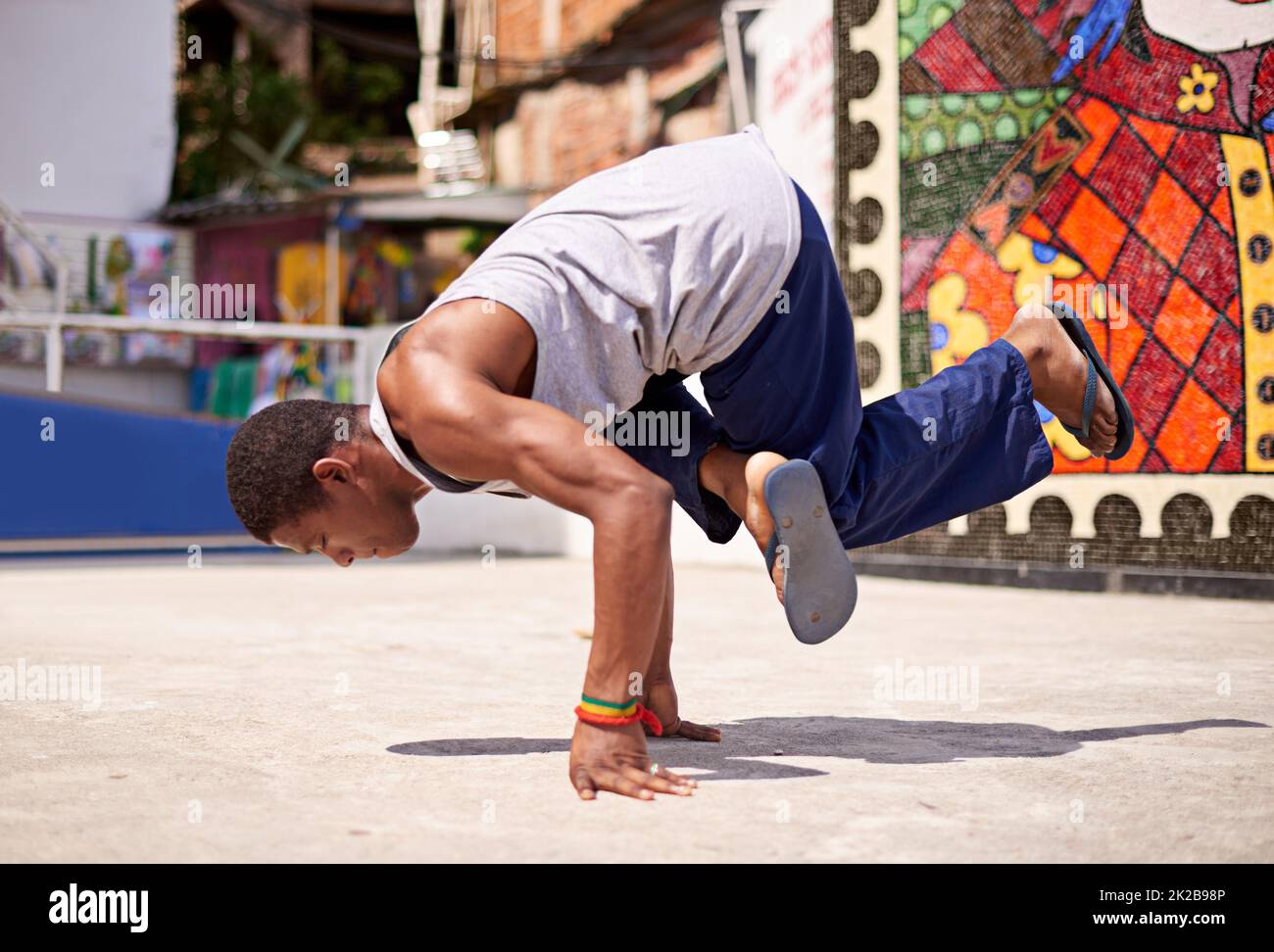 Cultura di Capoeira. Basso angolo di ripresa di un giovane uomo frangidanzatore in un ambiente urbano. Foto Stock