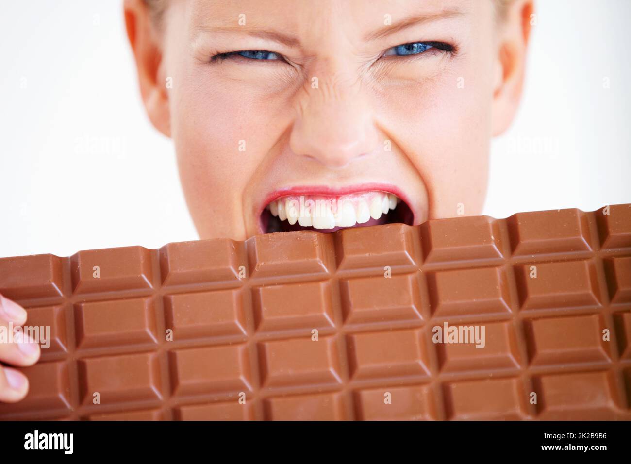 Devo mangiare tutto. La giovane donna ha un'enorme fetta di cioccolato. Foto Stock