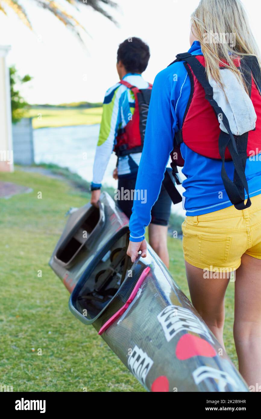 Theyre pronto per l'acqua. Un'immagine ritagliata di due giovani che trasportano un kayak. Foto Stock