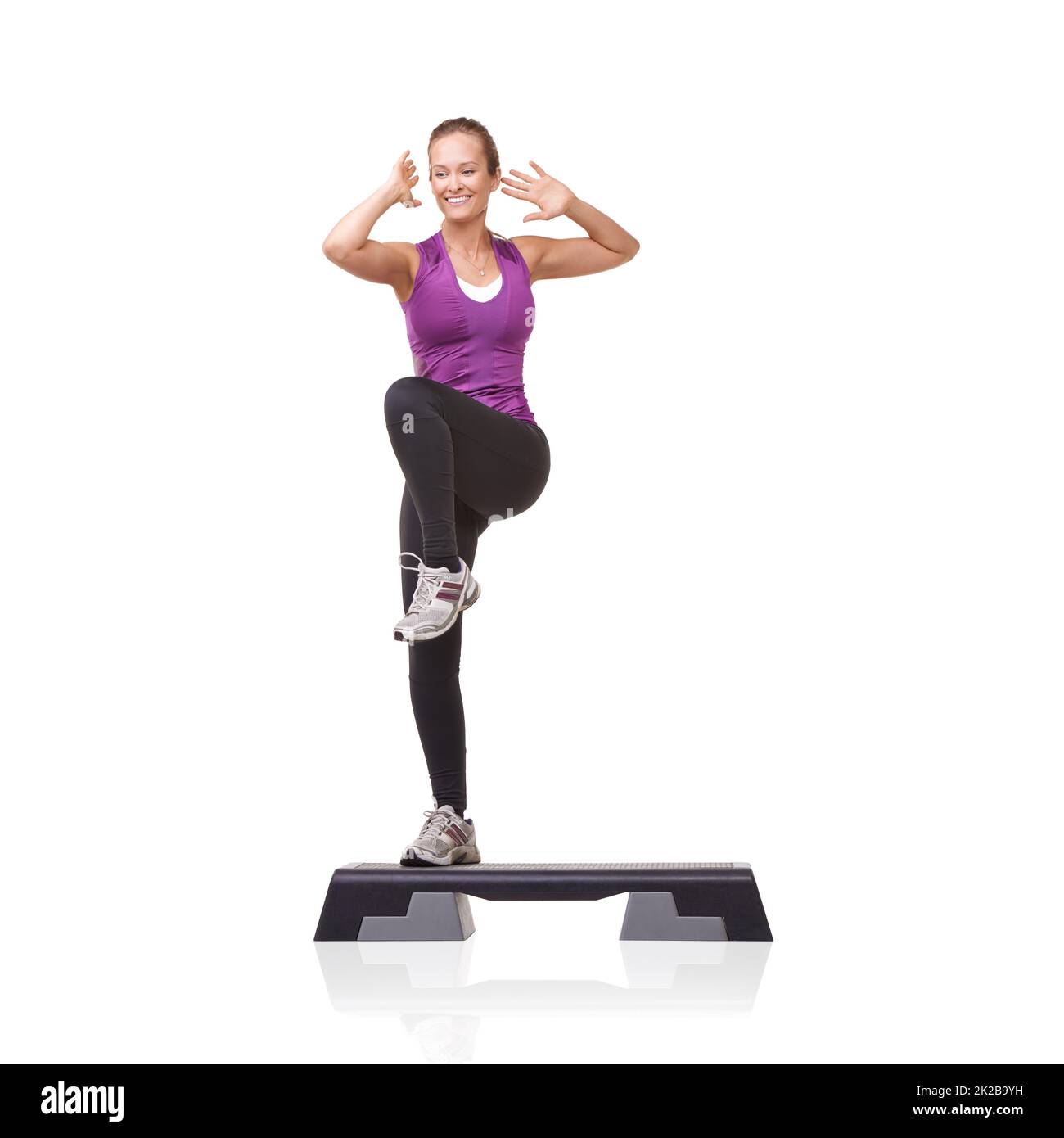 Verso una salute migliore. Una giovane donna sorridente che fa aerobica su un punto aerobico contro uno sfondo bianco. Foto Stock