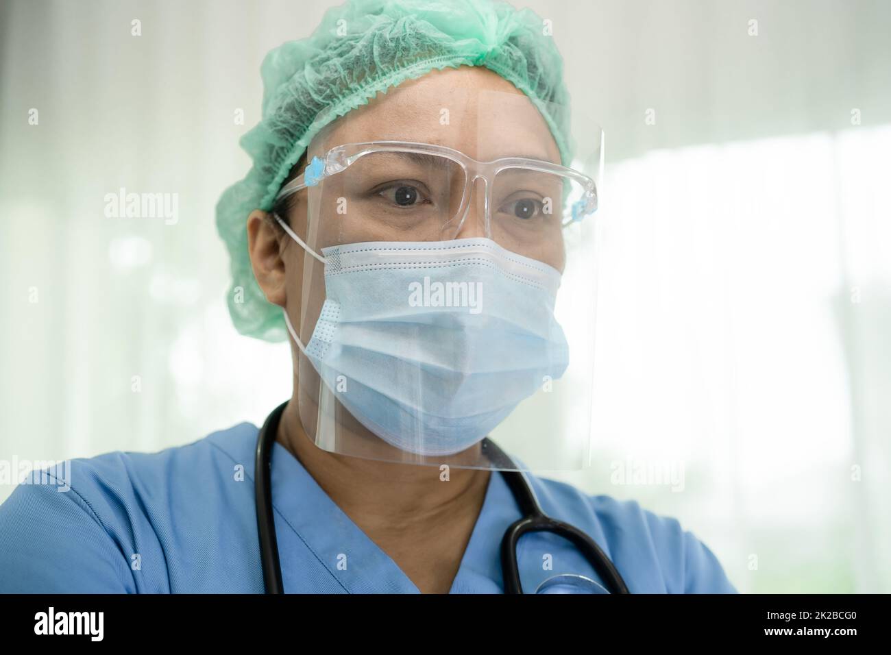 Medico asiatico indossare visiera e PPE tuta nuovo normale per controllare il paziente proteggere l'infezione di sicurezza Covid 19 Coronavirus focolaio in quarantena ospedale reparto infermieristico. Foto Stock