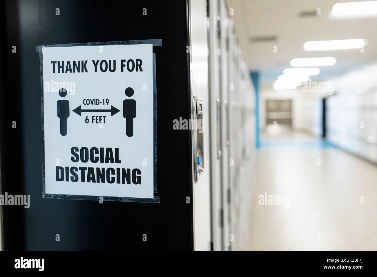 Poster della distanza sociale sul muro nel corridoio scolastico Foto Stock