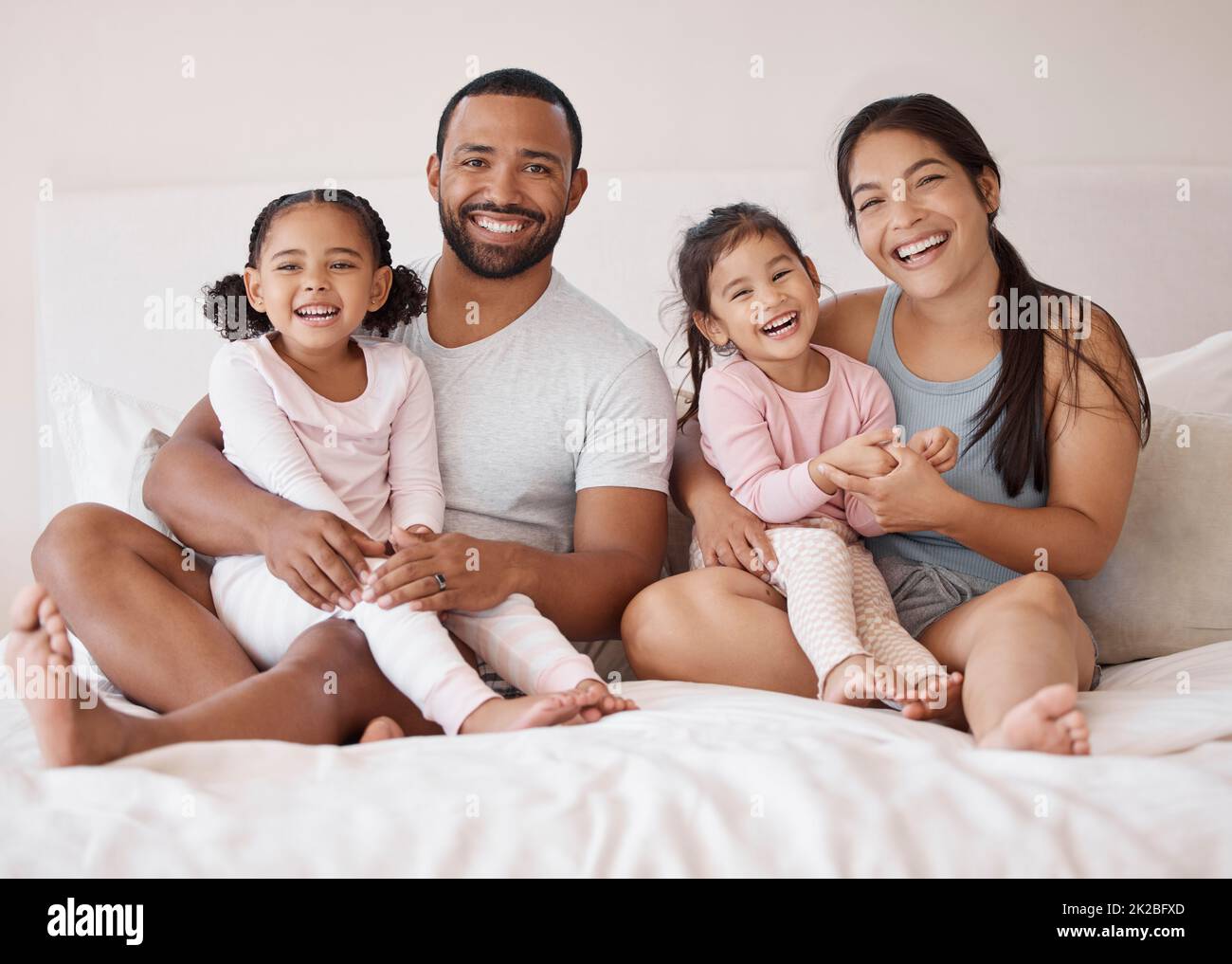 Mattina, amore e camera da letto con ritratto di una famiglia felice per stile di vita, sostegno e relax insieme. Felicità, casa di famiglia e sorriso con i genitori Foto Stock