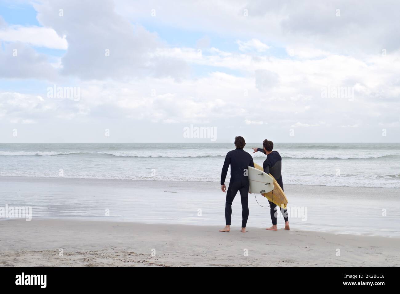 Surf con il mio migliore compagno. Due giovani surfisti sulla spiaggia. Foto Stock