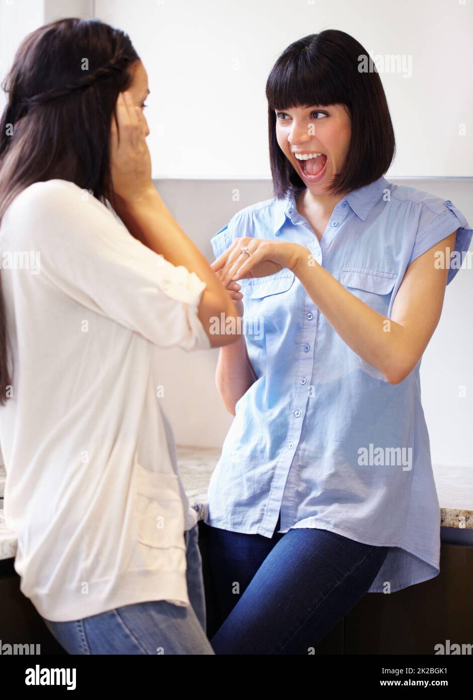 Ho detto di sì. Una giovane donna eccitata che mostra il suo anello di fidanzamento al suo amico estatico. Foto Stock