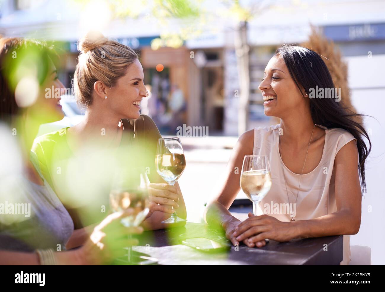 Shes un po 'di un enogastronomia. Scatto corto di tre donne gustando un bicchiere di vino bianco in un caffè sul marciapiede. Foto Stock