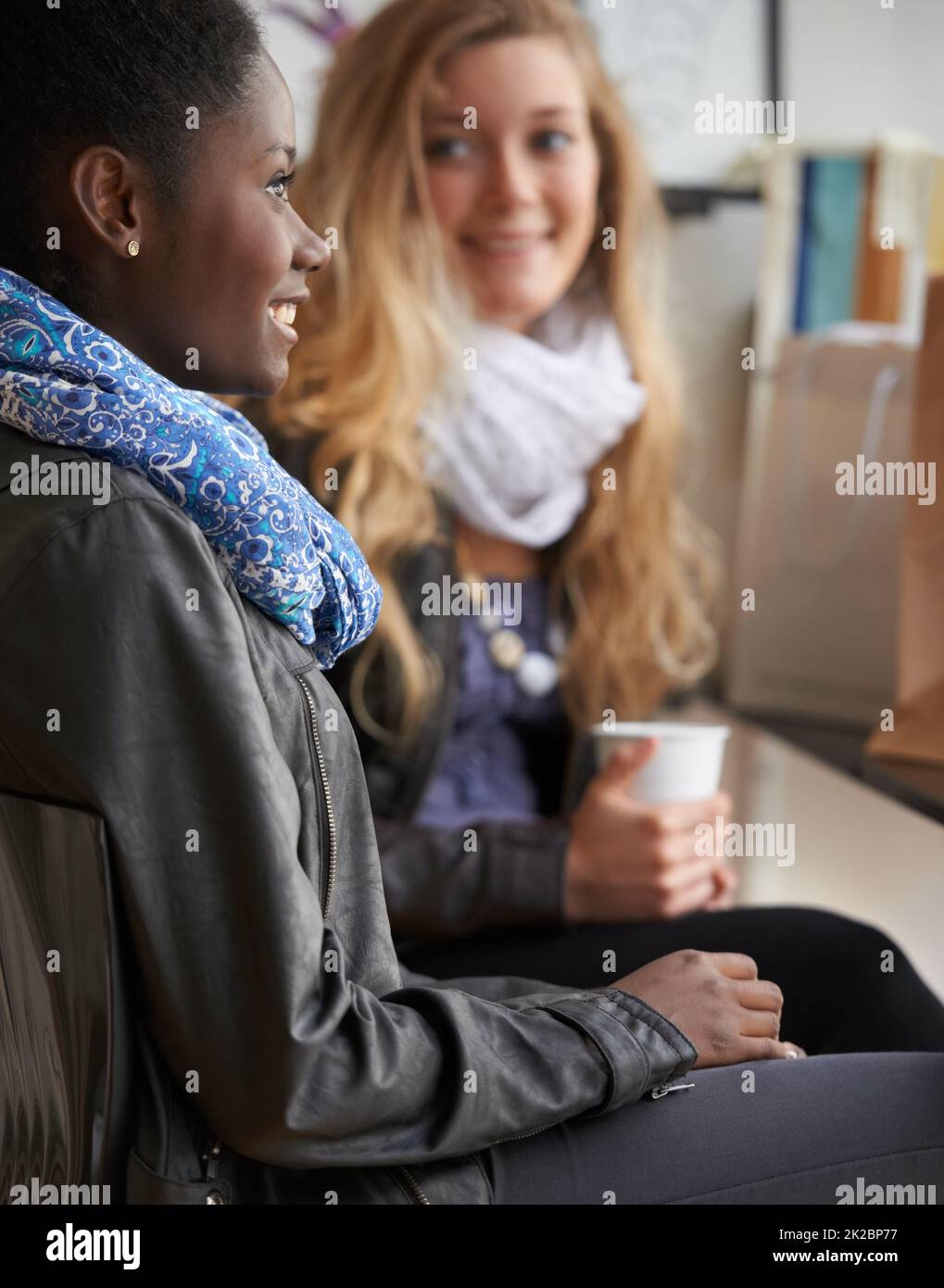 Gustare una tazza di caffè insieme. Due giovani donne che acquistano caffè insieme. Foto Stock