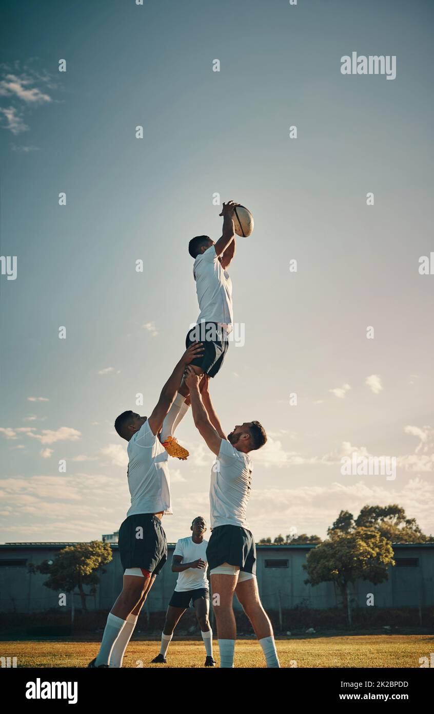 E hes lo ha ottenuto. Scatto corto di un bel giovane giocatore di rugby che cattura la palla durante un allineamento sul campo. Foto Stock