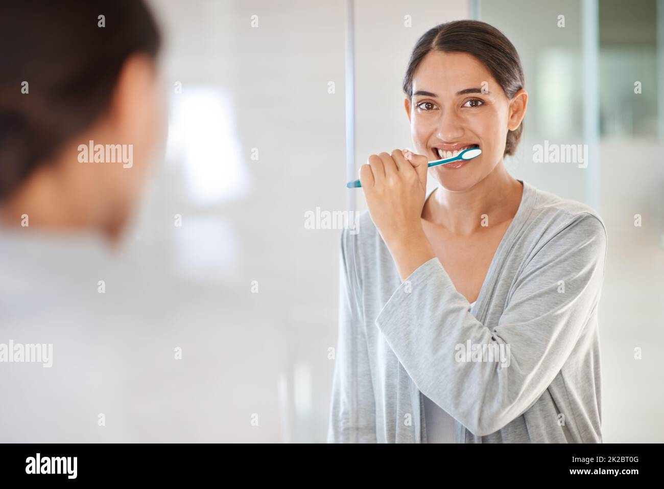 Prendersi cura del suo sorriso. Una giovane donna che le spazzolava i denti. Foto Stock