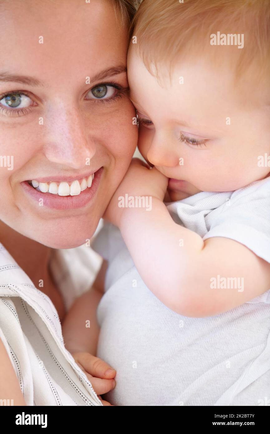 Tenendosi vicino al suo piccolo uomo. Primo piano di una giovane madre e del suo adorabile figlio. Foto Stock