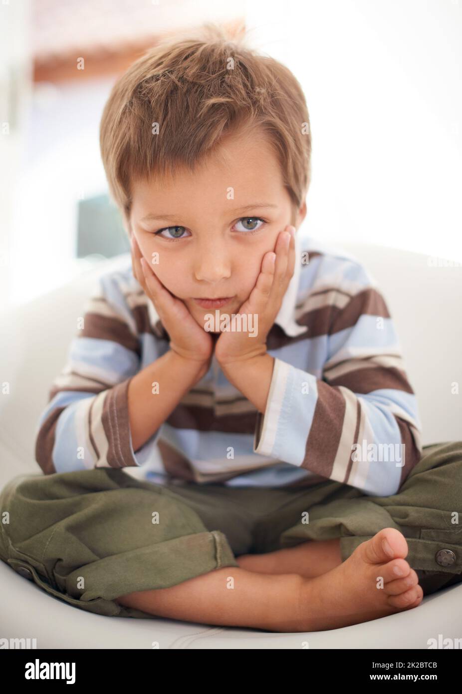 Non sono io. Un ragazzino seduto tristemente dopo essere stato rimprovero. Foto Stock