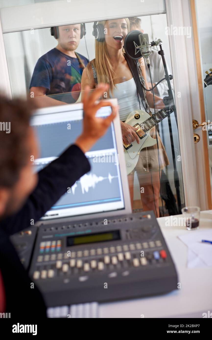 Passo perfetto. Un artista di registrazione gesturing ad un cantante in un modo di approvazione. Foto Stock