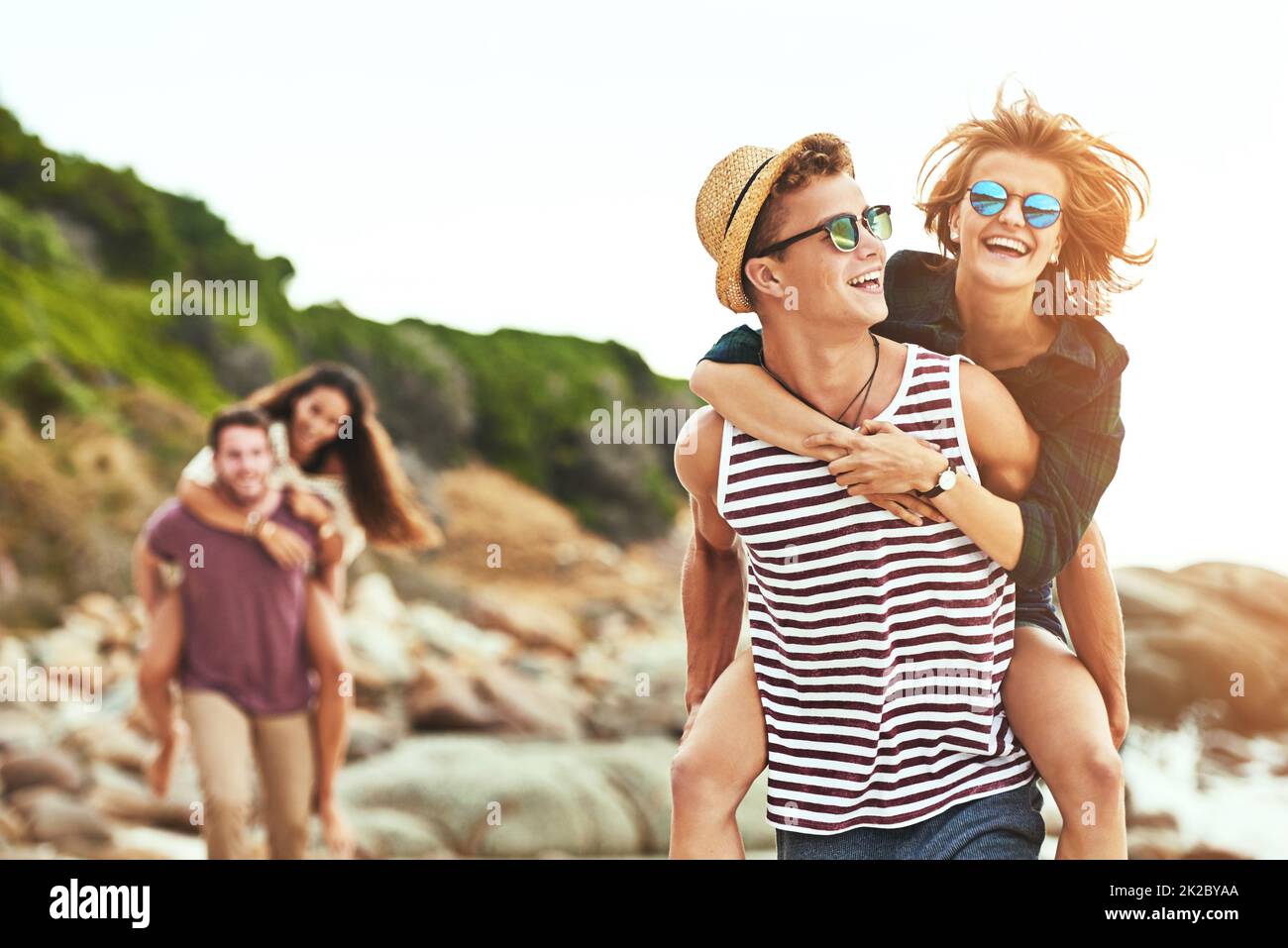 Dimmi dove vuoi andare Scatto corto di due giovani coppie affettuose godendo il loro tempo sulla spiaggia. Foto Stock