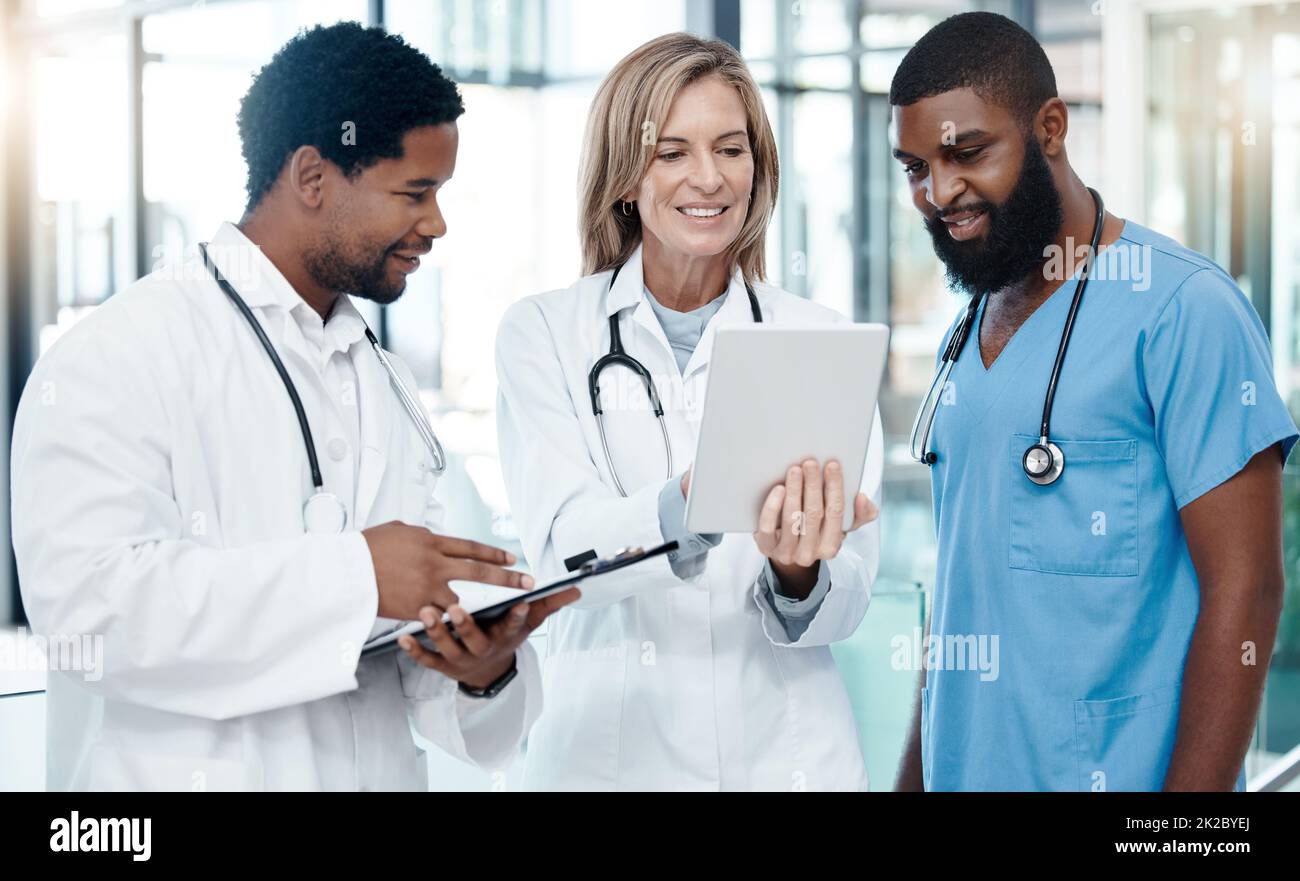 Medici, riunioni e tablet per la pianificazione sanitaria utilizzando l'informatica per lo sviluppo medico, parlando di medicina. Team sanitario Foto Stock