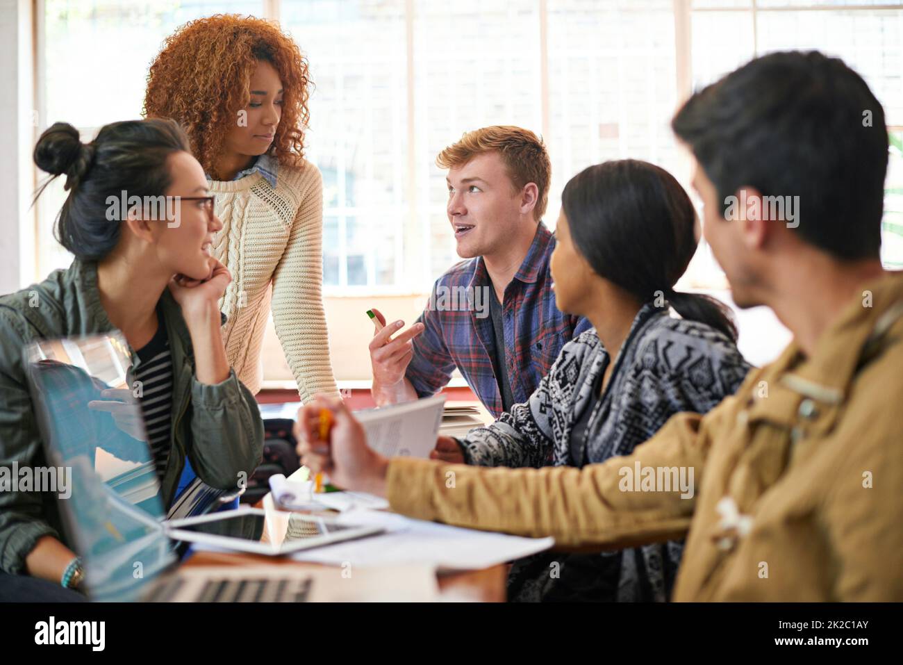 Spiegare alcune note della classe. Shot di studenti che si aggrappano tra una classe e l'altra. Foto Stock