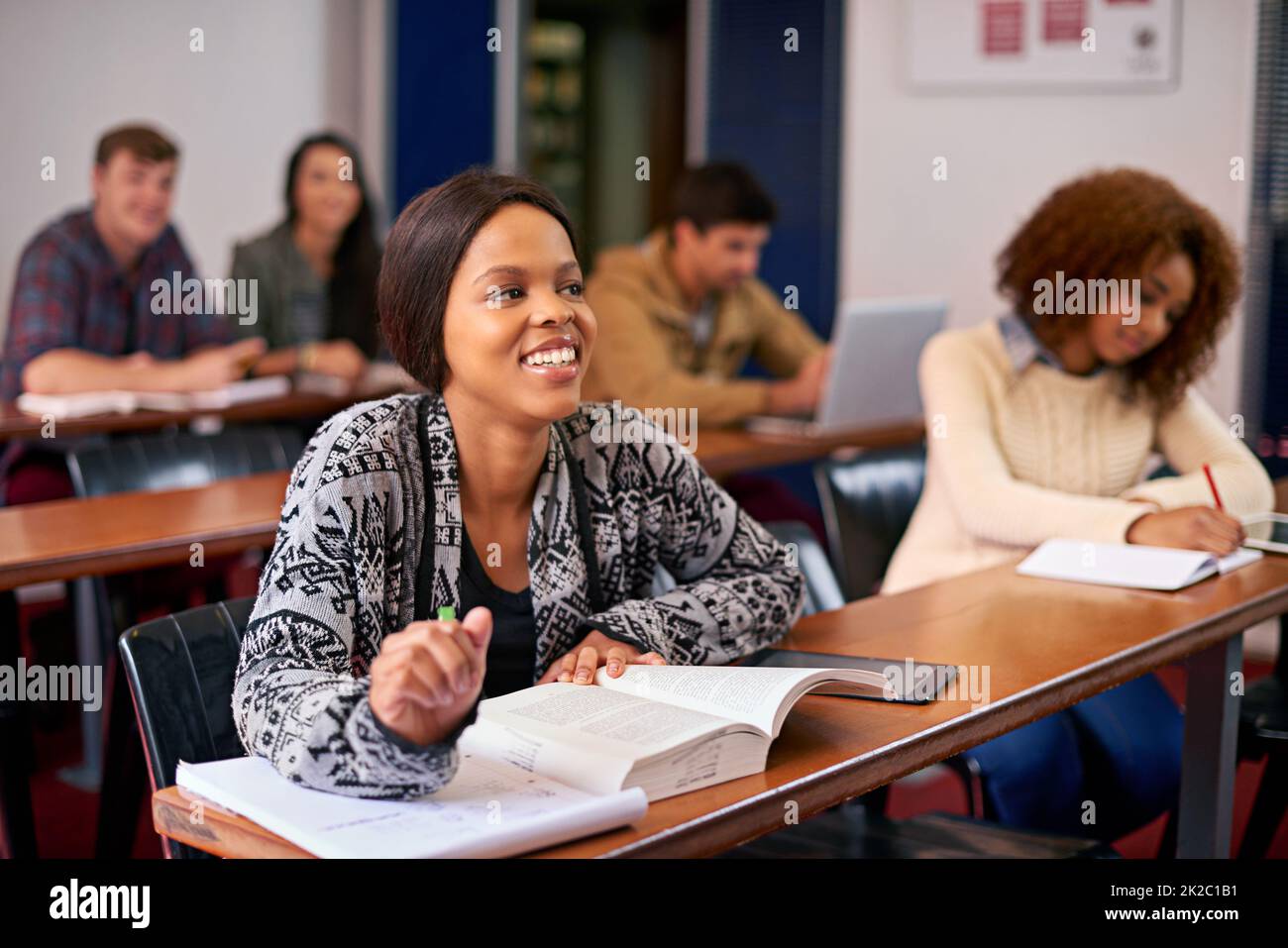 Promuovere la loro formazione. Scatto di uno studente felice che presta attenzione in classe. Foto Stock