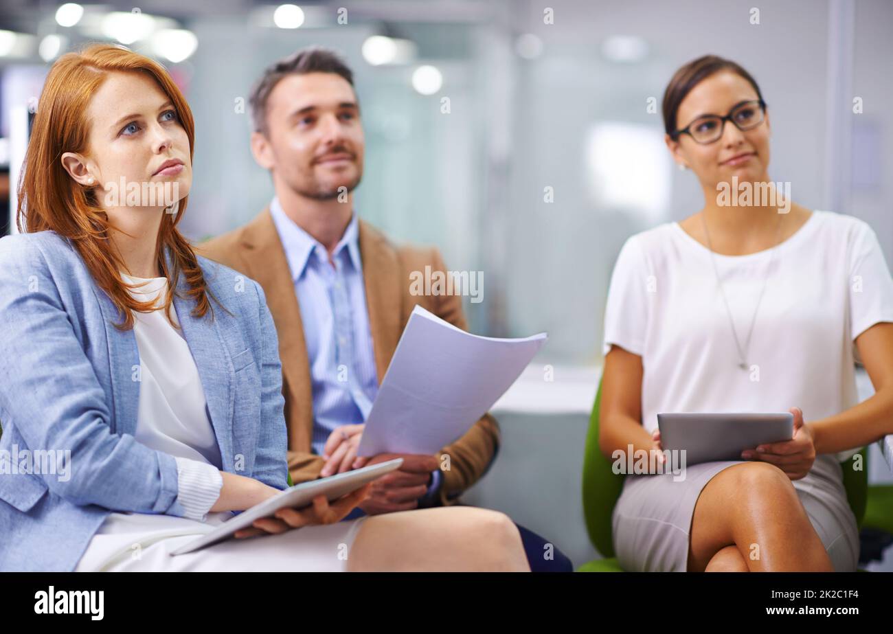 Prestare particolare attenzione alla presentazione. Scatto di tre colleghi che ascoltano una presentazione. Foto Stock