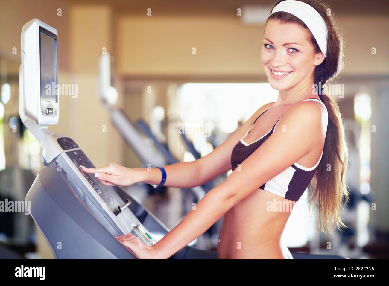 Passo verso il fitness. Una giovane donna attraente che usa una macchina del gradino nella palestra. Foto Stock