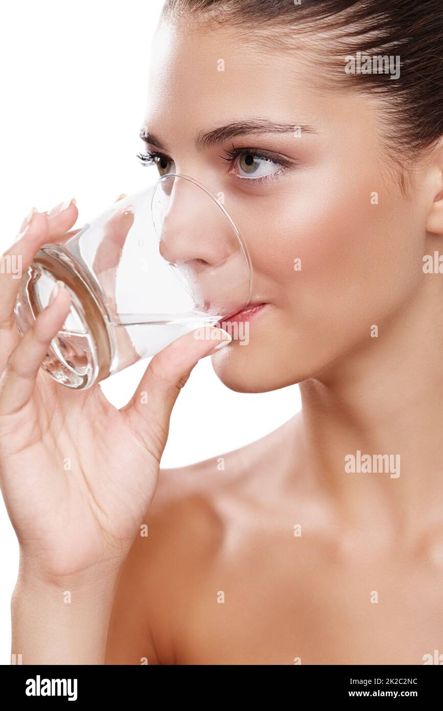 Mantenere idratato. Studio girato di una giovane donna prendendo un sorso d'acqua. Foto Stock